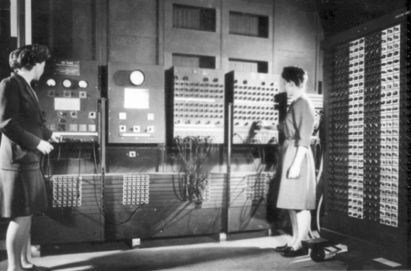 Das Foto zeigt zwei Frauen, die an der ENIAC-Maschine arbeiten.